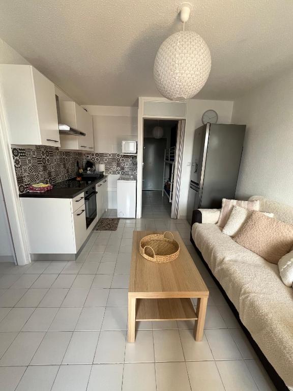 un salon avec un canapé et une table dans l'établissement Appartement 2 pièces + cabine, 6 couchages, au Grau-du-Roi