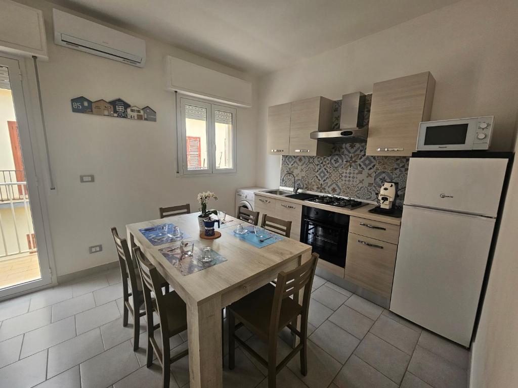 a kitchen with a table and a white refrigerator at SolMarina Holiday House in Marina di Ragusa