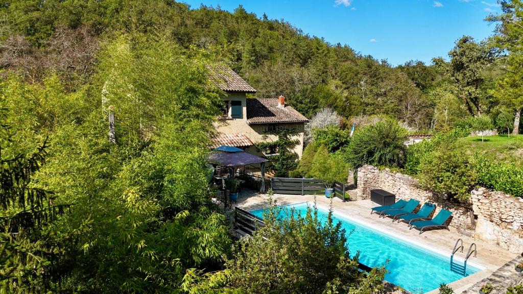 a villa with a swimming pool and a house at La Papèterie chambres de charme in Gavaudun