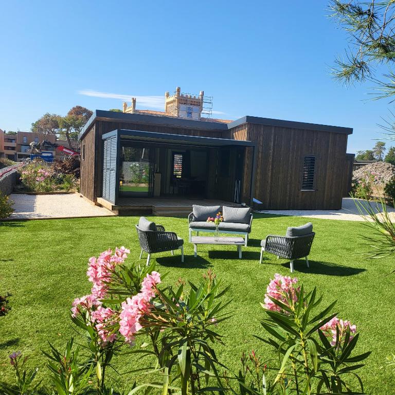 une maison avec un canapé et des chaises dans une cour dans l'établissement Cottage Cap d Agde, à Agde