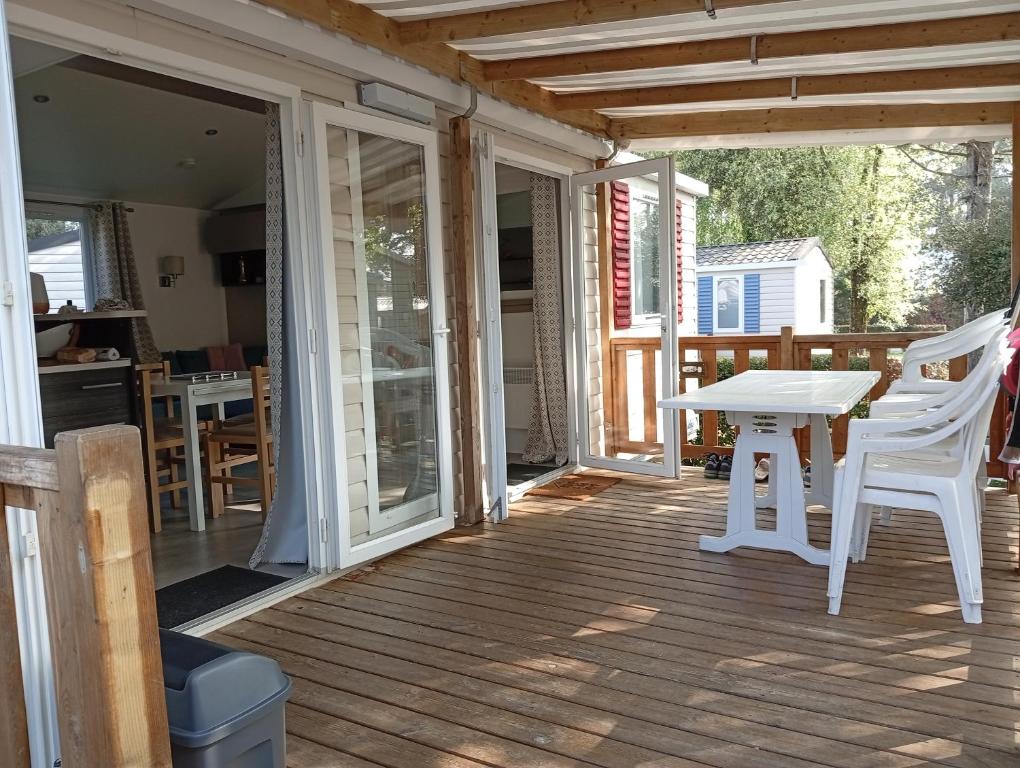 un patio avec une table et des chaises sur une terrasse dans l'établissement joli mobile home 3 chambre 334, à Saint-Jean-de-Monts