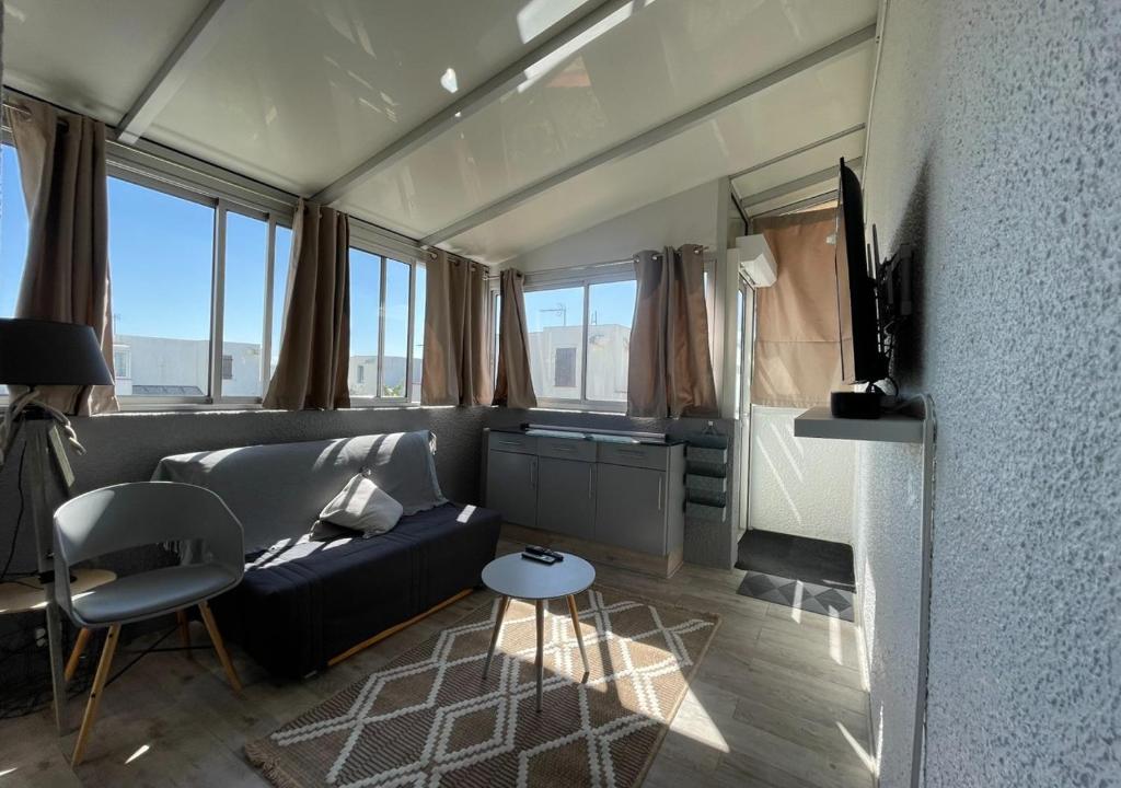 un salon avec un canapé et une table dans l'établissement Windy Barcarès 200 m de la mer, au Barcarès