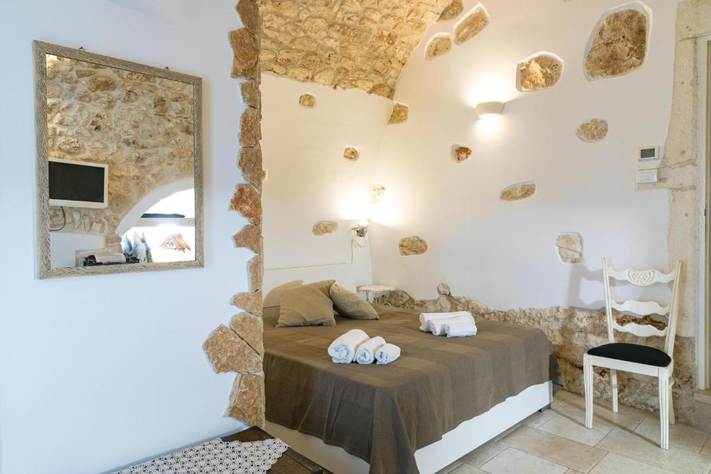 sypialnia z łóżkiem z lustrem i krzesłem w obiekcie Casa Gioia Ostuni w mieście Ostuni