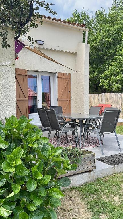 un patio avec une table et des chaises devant une maison dans l'établissement I Tre Taglincchi, U Terzu - Proche mer, Clim, Wifi, Parking gratuit, à Taglio-Isolaccio