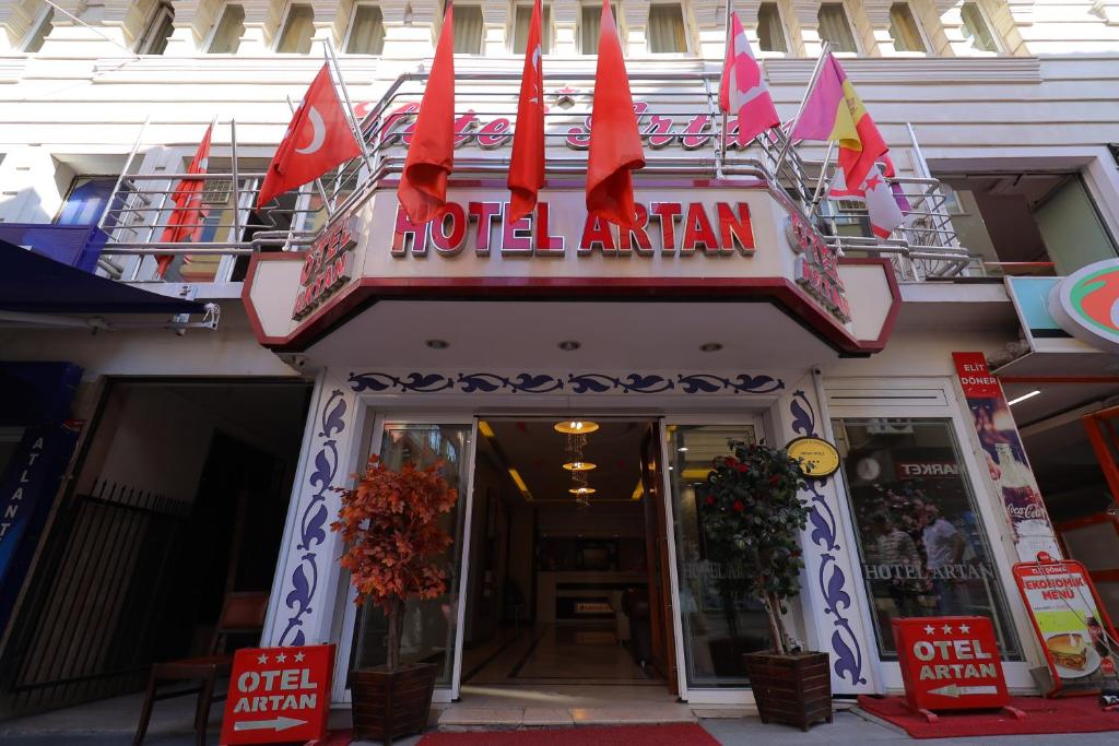 Una entrada de hotel con banderas rojas delante en Artan Hotel, en Isparta