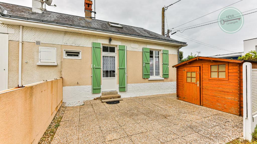 une maison avec un garage orange et vert dans l'établissement Studio mezzanine Seringas, à Plage-des-Demoiselles