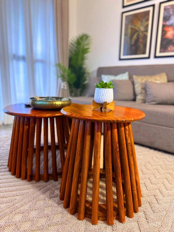 two round wooden tables in a living room at The Home Kololo in Kampala