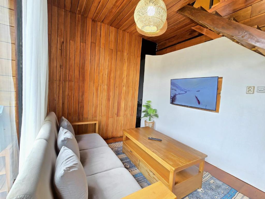 a living room with a white couch and a table at Cabin Linggayoni dieng in Dieng