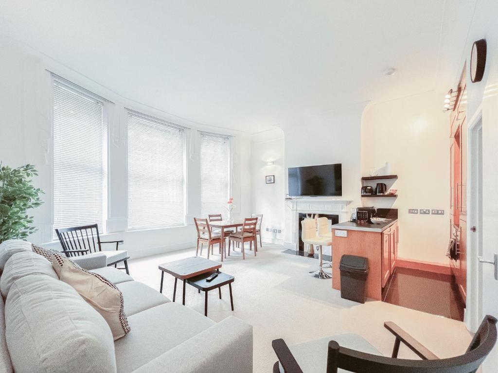 ein Wohnzimmer mit Sofa und Tisch in der Unterkunft The Fitz Central Apartment in London