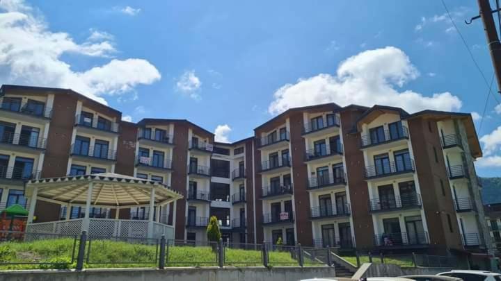 a row of apartment buildings with a fence in front at Salome in Itʼkhvisi