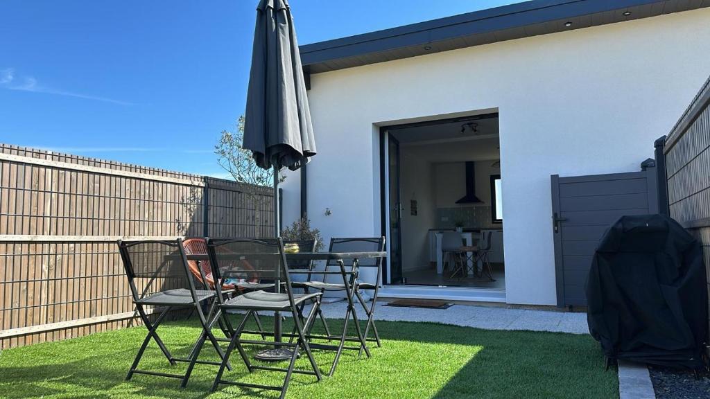 une terrasse avec une table, un parasol et des chaises dans l'établissement Ti case, à Gonneville-en-Auge
