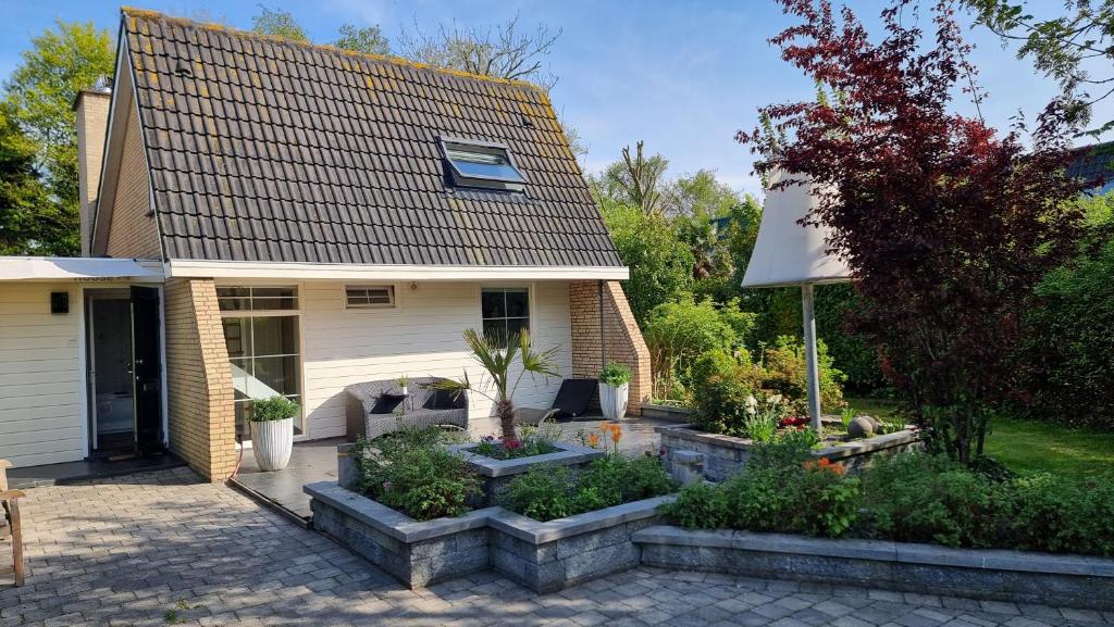 a house with a garden in front of it at Lake House 74, luxury accommodation ir Sauna in Warmond