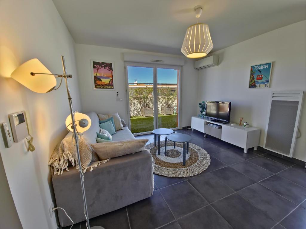 un salon avec un canapé et une télévision dans l'établissement Rooftop du Lavandou - terrace and pool, au Lavandou