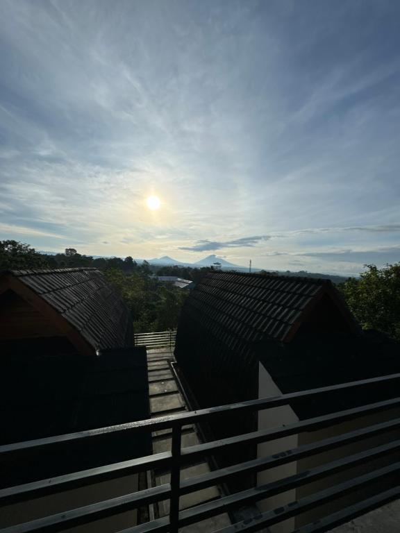 a view of the sun setting over the roofs of buildings at RDA BATURITI VILLA bali in Baturiti