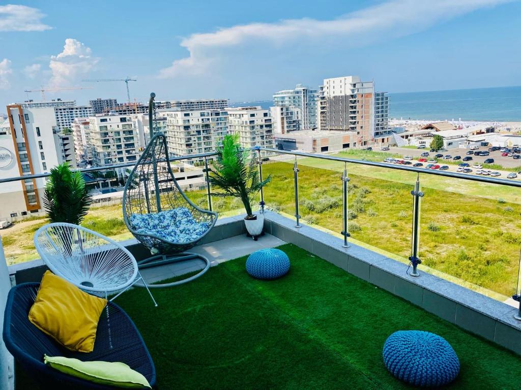 a balcony with two swings and green grass at Dolce Aqua Summerland Apartments in Mamaia