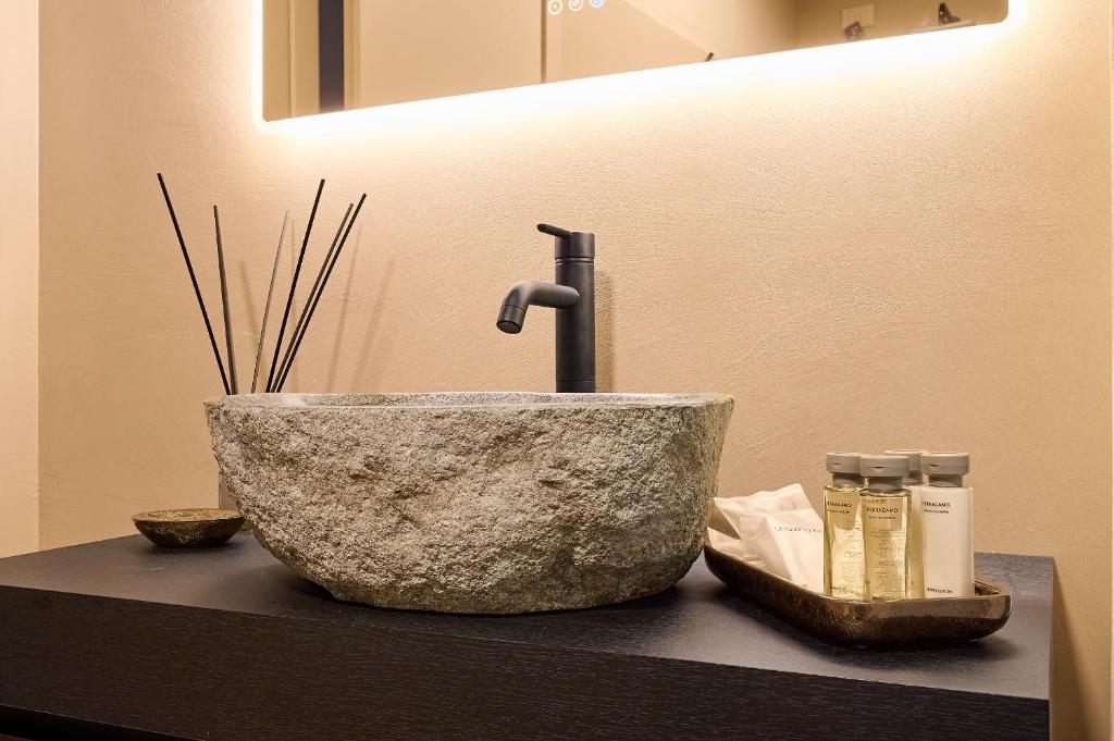 un lavandino in bagno con una ciotola in pietra su un bancone di My Home For You - Città Alta a Bergamo