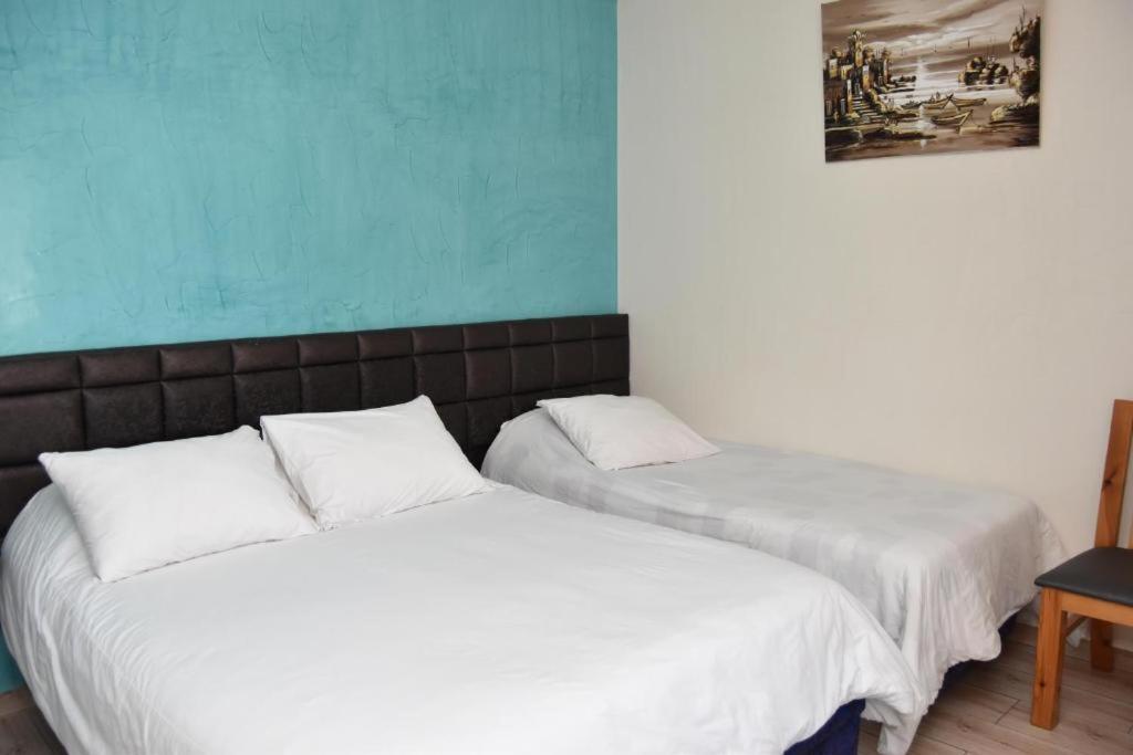 two beds sitting next to each other in a room at Hotel L'Initiale in Oualidia