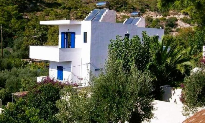 a white house on top of a hill with trees at Villa Joseph in Agia Fotia