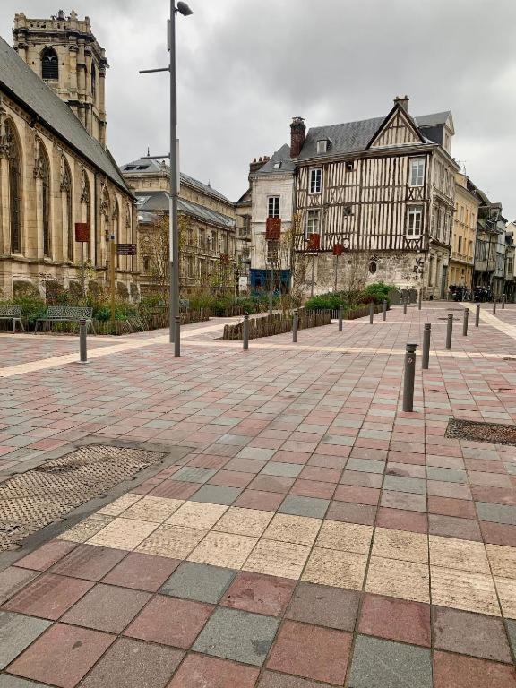 une rue urbaine avec des bâtiments et un éclairage de rue dans l'établissement Confortable Studio dans le Centre historique de Rouen - 001, à Rouen