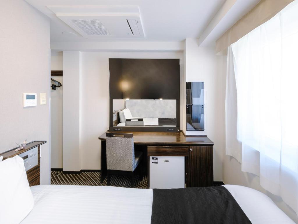 Postel nebo postele na pokoji v ubytování APA Hotel Yokohama Kannai