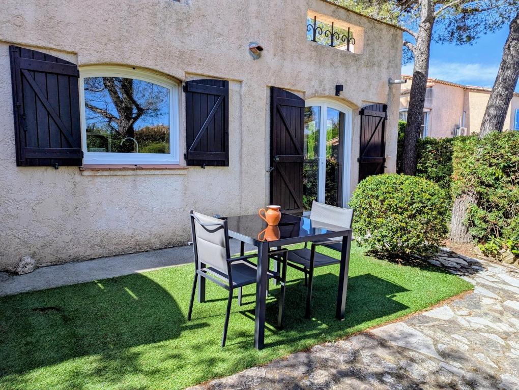 une table et des chaises devant une maison dans l'établissement Eucalyptus, calme entouré de verdure et près de la mer, à Saint-Aygulf