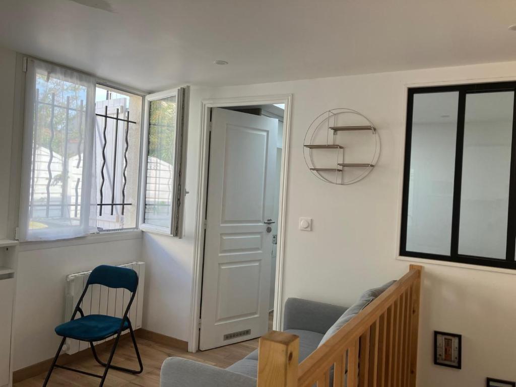 un escalier avec une chaise bleue dans une pièce dans l'établissement Fluo's small house, à La Courneuve