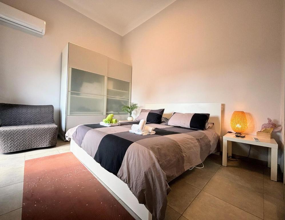 Un dormitorio con una cama grande y un sofá. en - Seaside Nest-Free Parking & Beach, en Marina di Carrara