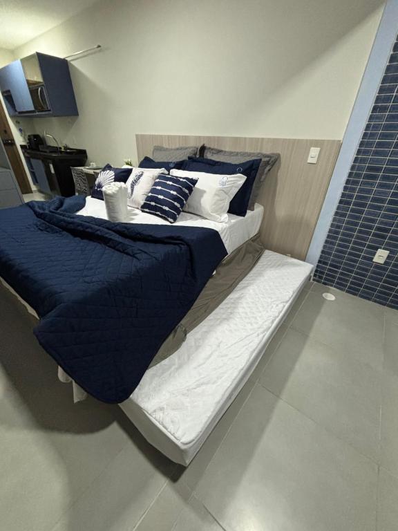 a large bed with blue and white sheets and pillows at Ora Beach 108 Porto de Galinhas in Porto De Galinhas