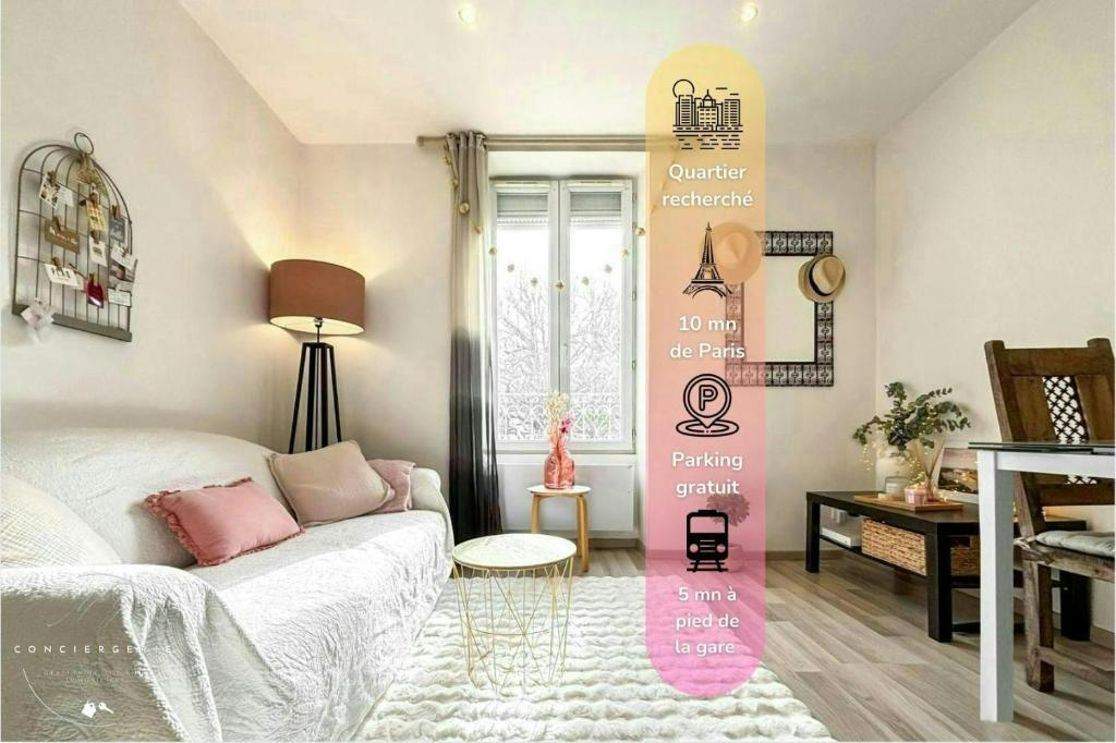 un salon avec un canapé blanc et une table dans l'établissement Cozy appartement Bords de Marne, à Saint-Maur-des-Fossés