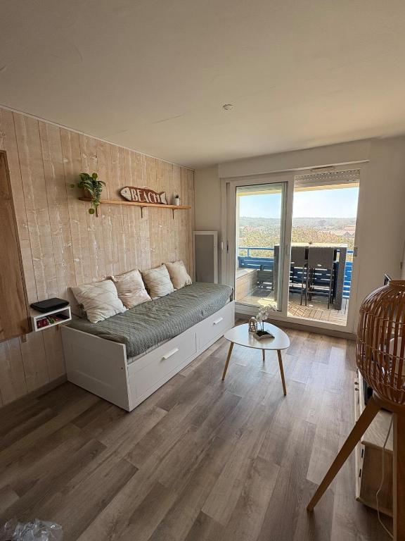 une chambre avec un lit, une table et une fenêtre dans l'établissement Bel appartement en bord de mer, à Lacanau