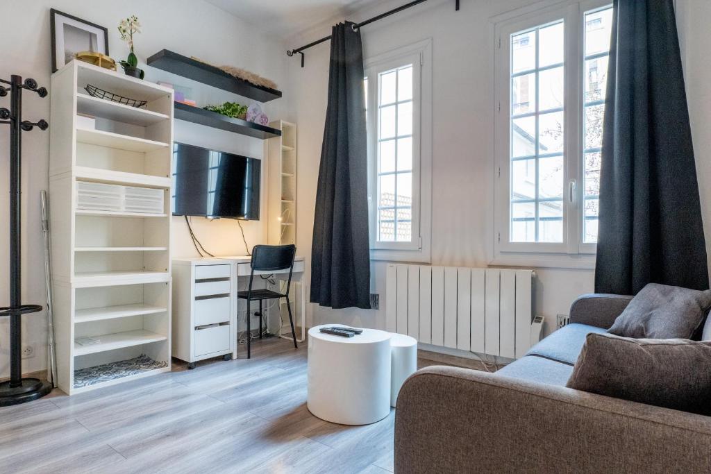 un salon avec un canapé et un bureau dans l'établissement Studio au centre de Paris, à Paris