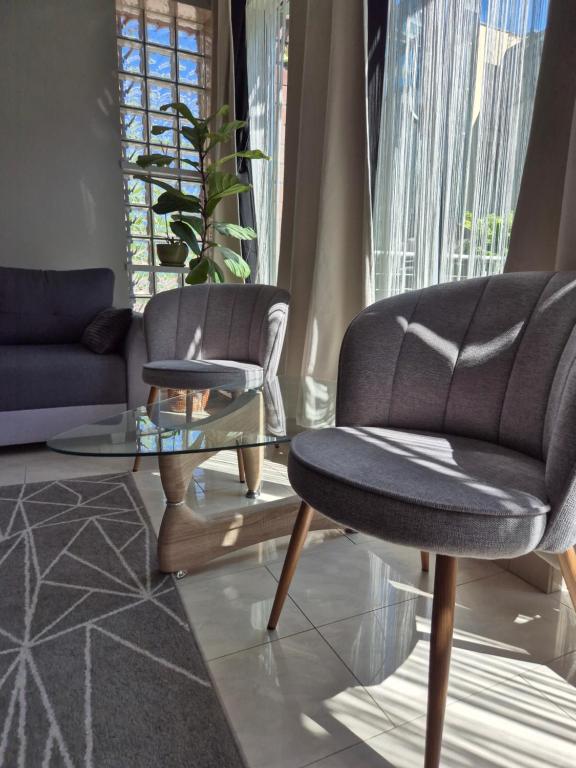 a living room with two chairs and a glass table at Apartament z tarasem Zeta Park in Ustroń