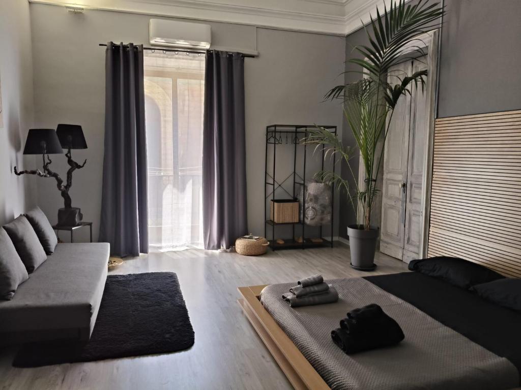 un soggiorno con un letto e un divano di Molo di Levante a Catania