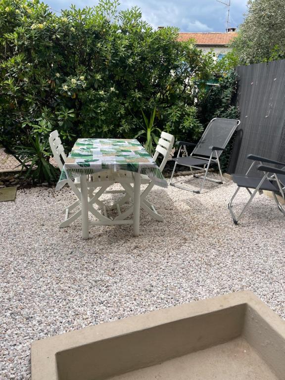 une table et des chaises assises sur une terrasse en gravier dans l'établissement Studio 100m plage, à Cagnes-sur-Mer