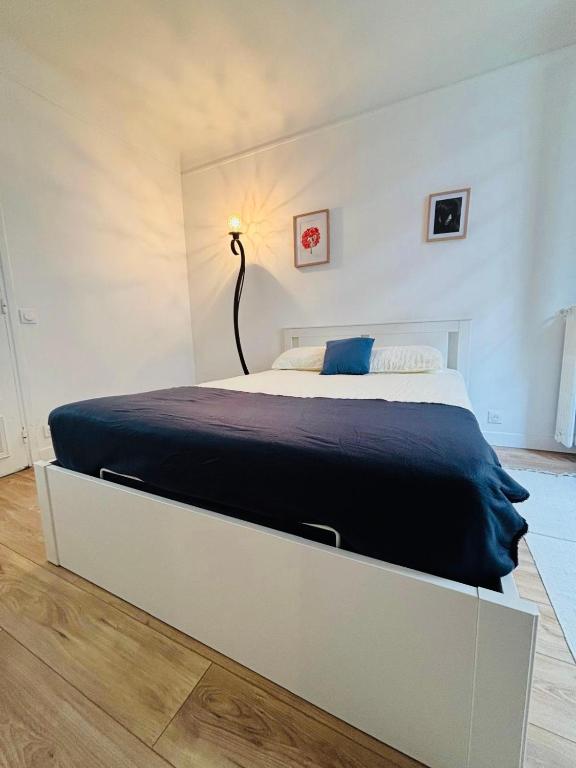 une chambre avec un grand lit avec une couverture bleue dans l'établissement Appartement Foch Champs Élysée, à Paris