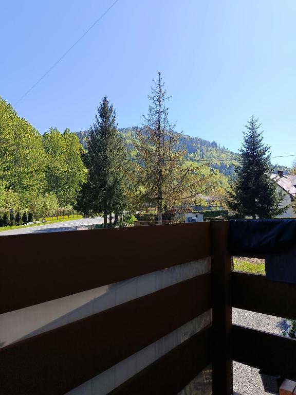 a fence with a view of a road and trees at Beskidzka Guest House in Szczyrk
