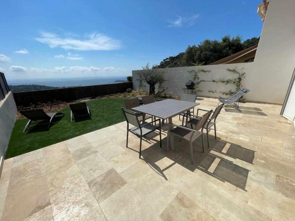 une table et des chaises sur une terrasse avec vue dans l'établissement Maison belle vue, à Cavalaire-sur-Mer