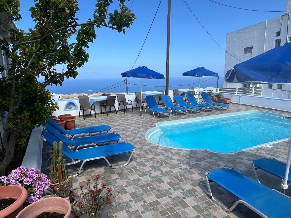 um pátio com cadeiras e uma piscina com vista em Stella Nomikou Apartments em Firostefani