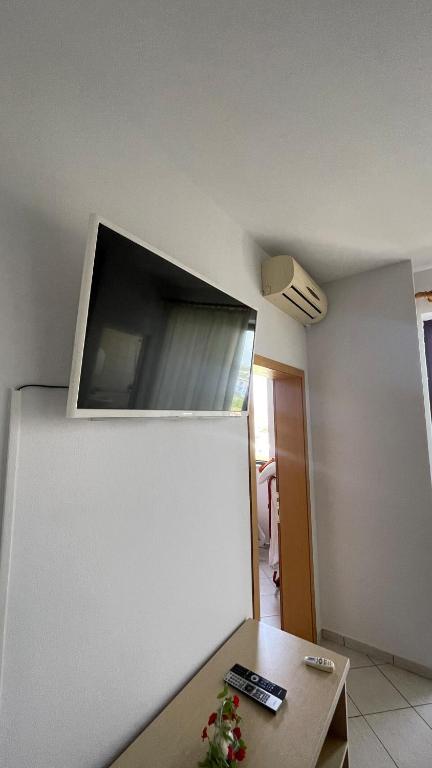 a room with a table and a tv on the wall at Bledi's Apartment Spille in Spille