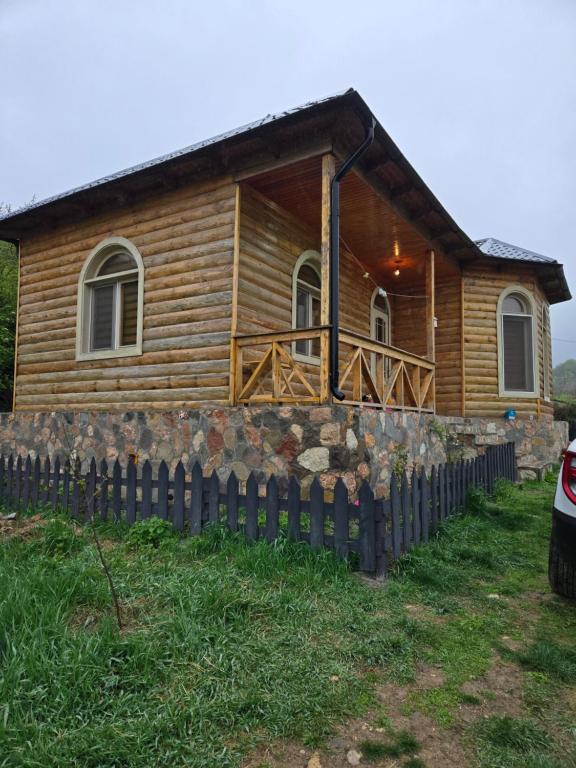 a log cabin with a fence in front of it at Shahdag wood house in Qusar