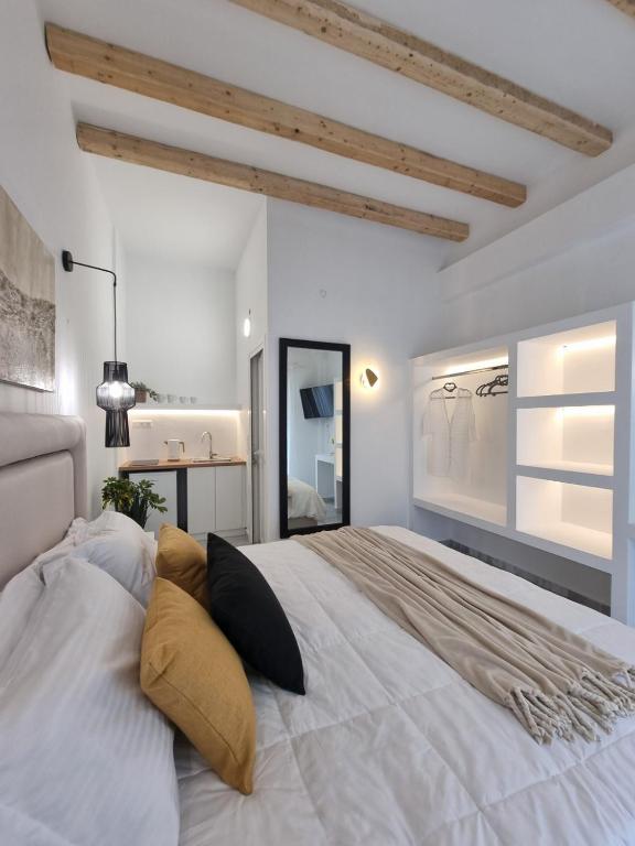 a bedroom with a large white bed with pillows at Europa Studios in Skala
