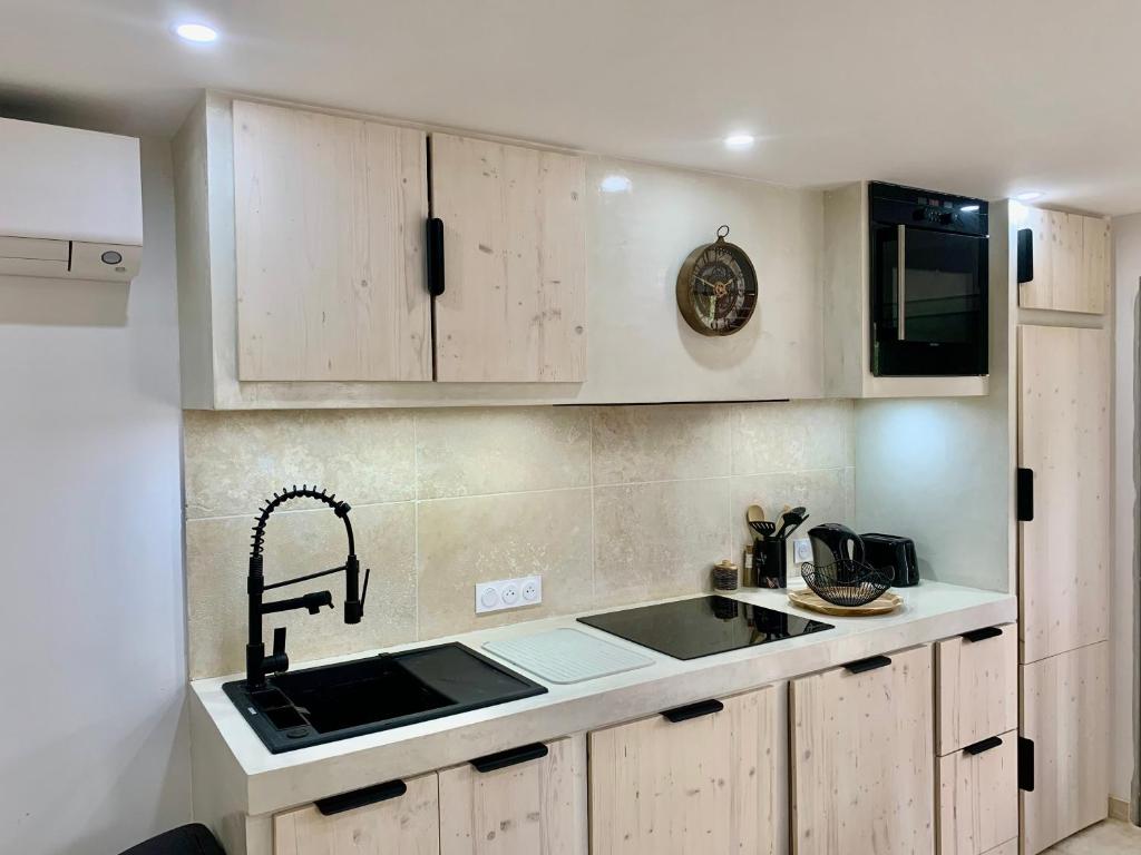a kitchen with white cabinets and a sink at Appartement 2 chambres 2 salles de bains haute ville in Porto-Vecchio