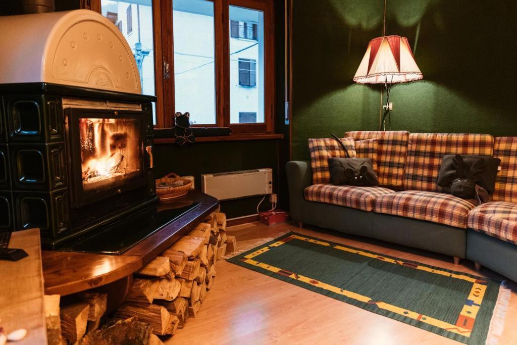 Una sala de estar con chimenea y un sofá. en Cà Nòno - Vista Mozzafiato sulle montagne, en Schilpario