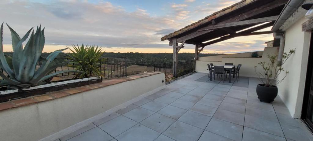 a balcony of a house with a table and chairs at Villa de Charme Climatisée - Au coeur des Remparts - Vue panoramique in Montpezat