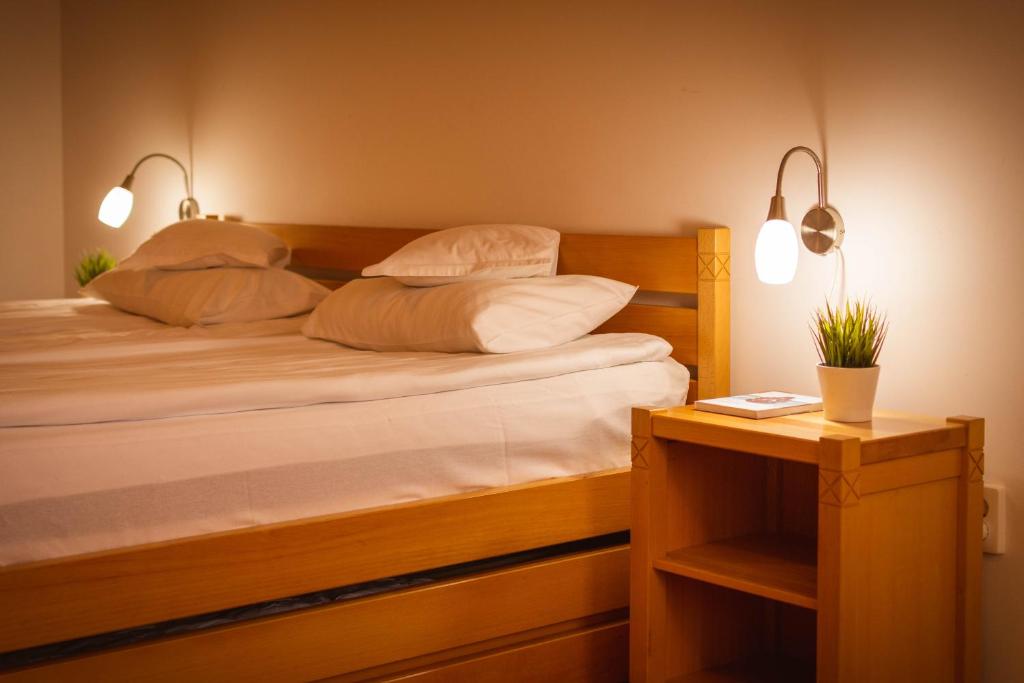 a bedroom with a bed with two pillows and a table at Lobogo Resort in Vlăhiţa