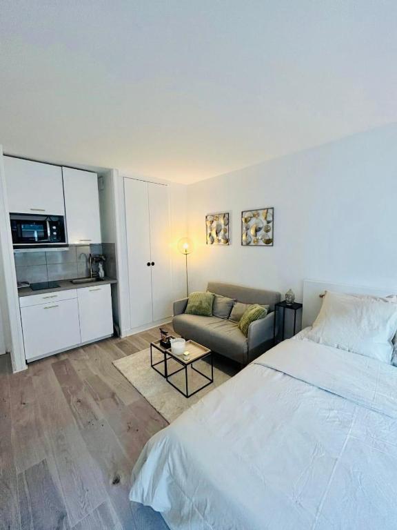 une chambre avec un grand lit et un canapé dans l'établissement Tour Eiffel Bir Hakeim 2, à Paris