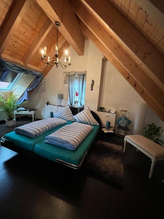 a bedroom with a large green bed in a attic at Gästehaus Jupp und Kerstin Korz GbR in Hackenheim