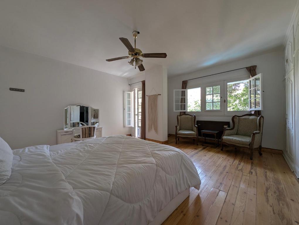 a white bedroom with a bed and a ceiling fan at Villa Maadi 35 -R 206 - Pool View Master Room in Cairo
