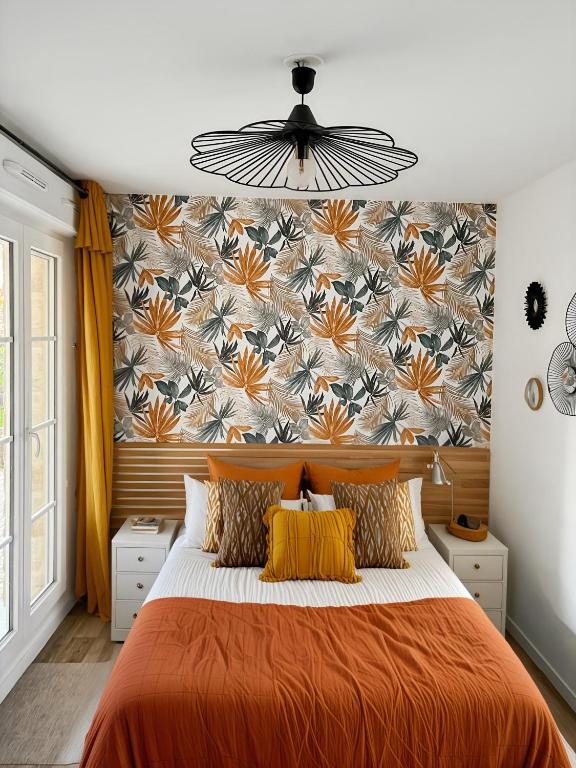 une chambre avec un lit orange avec un papier peint fleuri dans l'établissement Douceur Bohème Escale Conviviale Disneyland, à Villeneuve-Saint-Denis