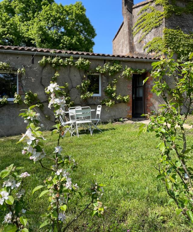 a house with a table and chairs in the yard at Gîte de la Rochejaquelein in Saint-Fulgent